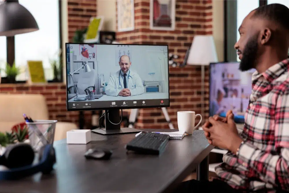 male employee chatting with doctor on telemedicine videocall conference using online telehealth using computer with webcam remotely 1 telemedicine