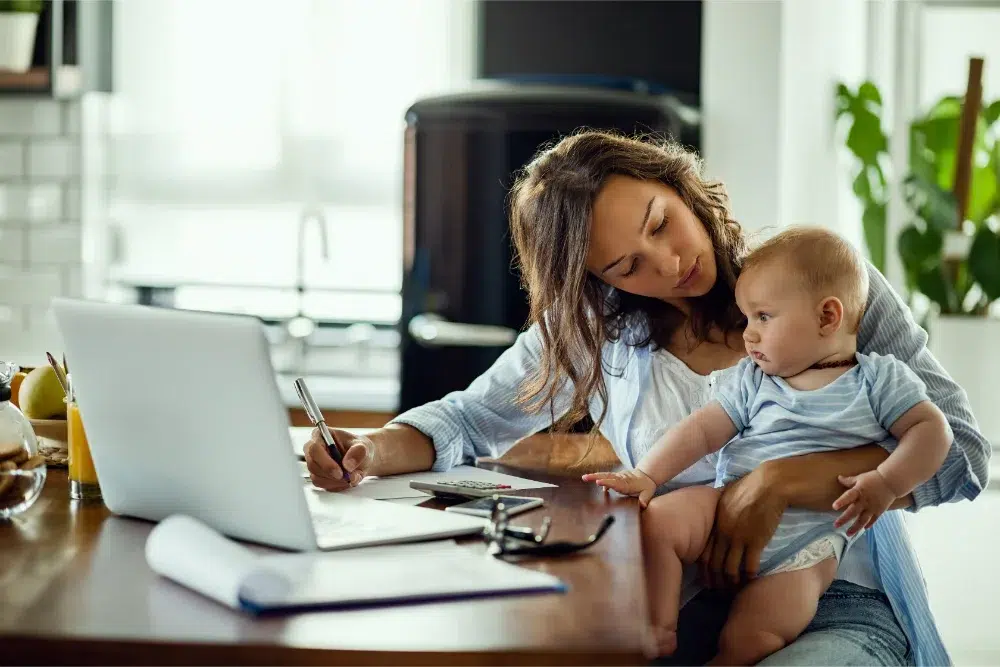 mother holding baby while working Compte de dépenses pour employés