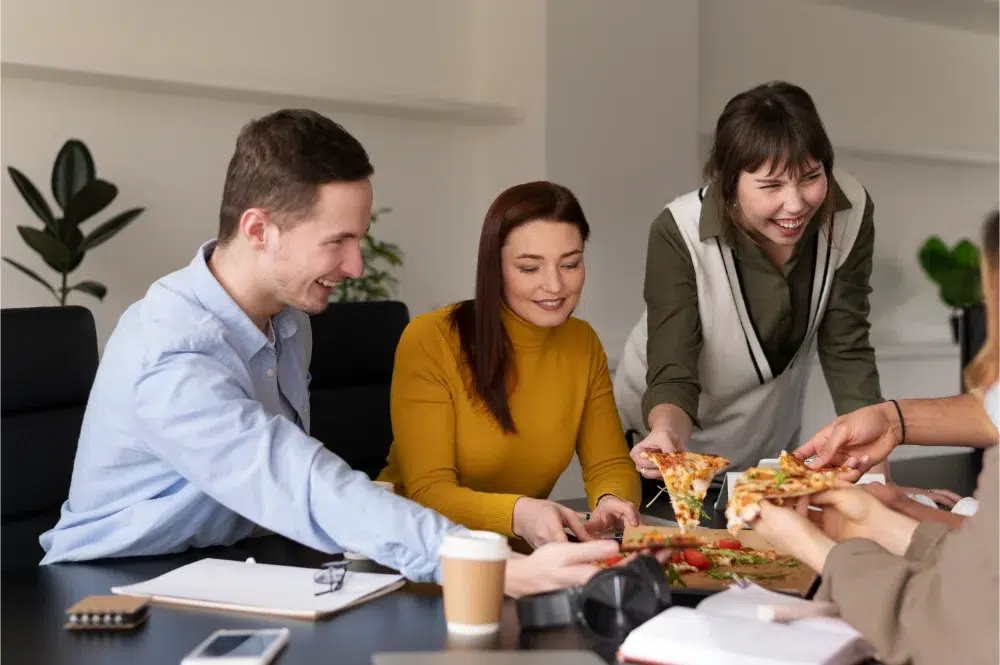 Office workers enjoying free food provided by companys work perks office workers enjoying free food provided by companys work perks