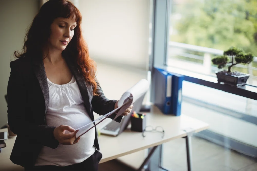 Pregnant business woman reviewing fertility spending account policy pregnant business woman reviewing fertility spending account policy