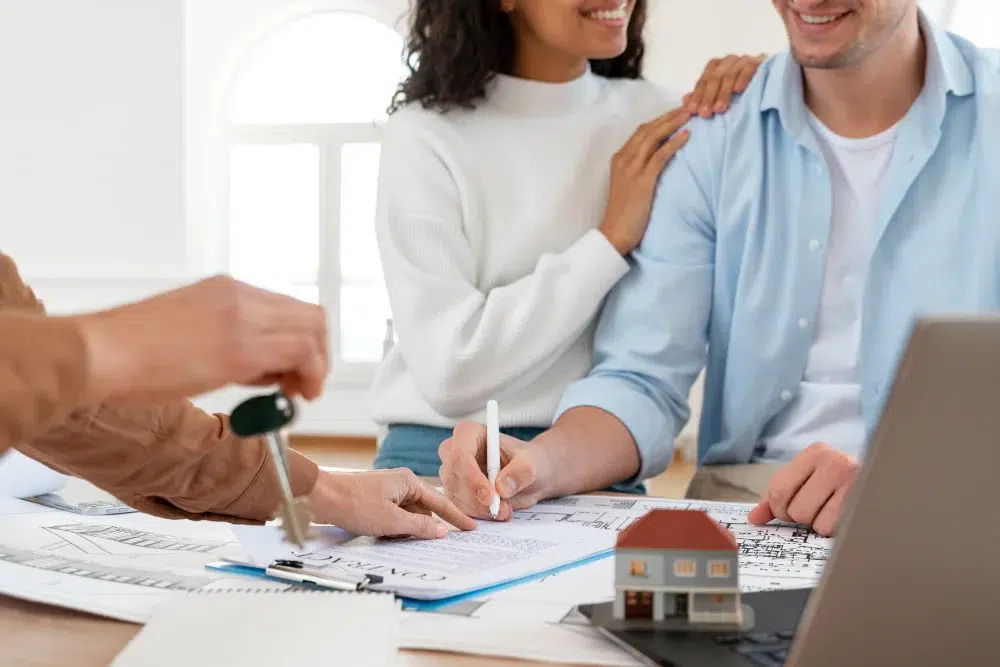 smiley couple signing contract for new house thanks to savings from workplace first home savings account First Home Savings Account