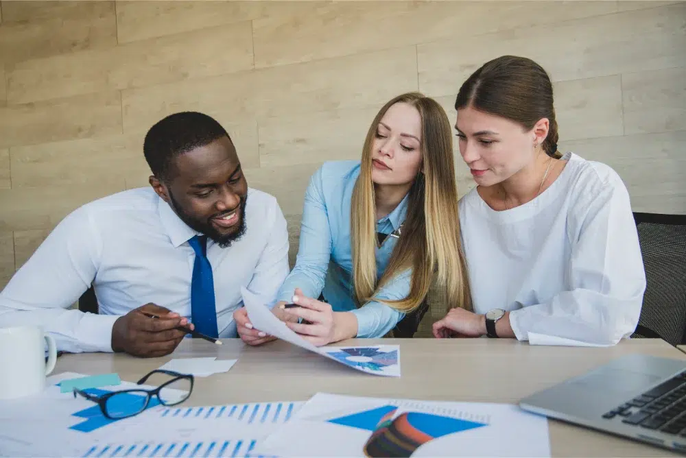 three office employees compararing equity compensation plans employee share purchase plan