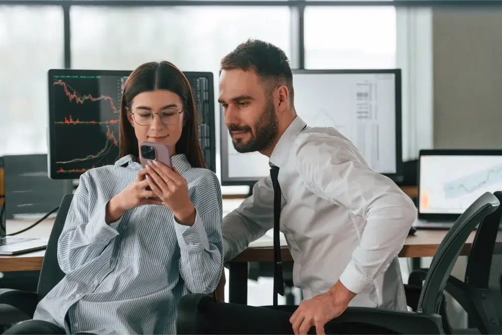 Two employees are in the office together looking over employee share purchase plan at work two employees are in the office together looking over employee share purchase plan at work